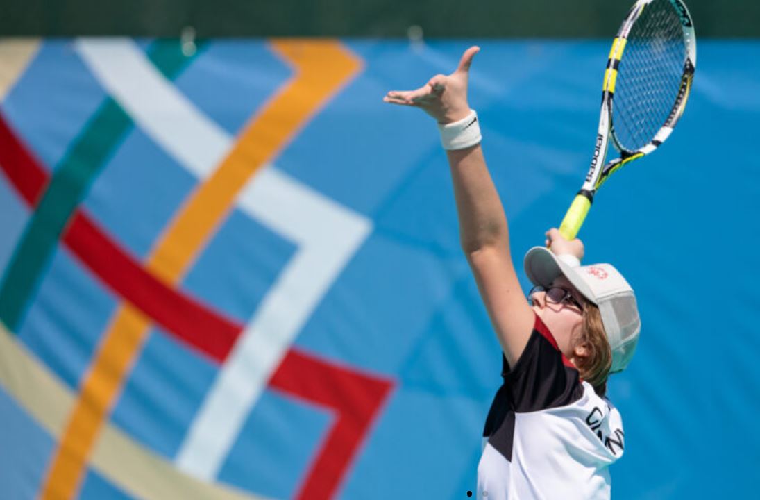 Frau holt mit ihrem Tennisschläger aus