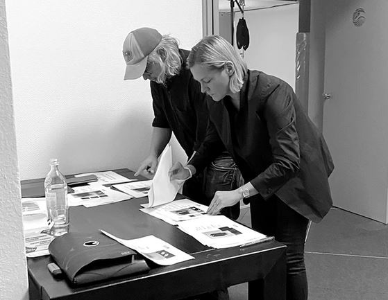 zwei Personen beugen sich vor dem Tisch und arbeiten